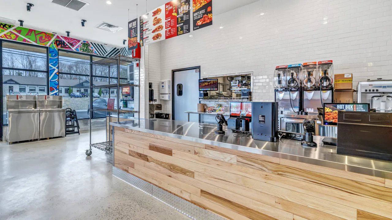 Interior view of Dave's Hot Chicken at 106 Federal Rd, Brookfield, CT, featuring a modern counter and vibrant wall art.