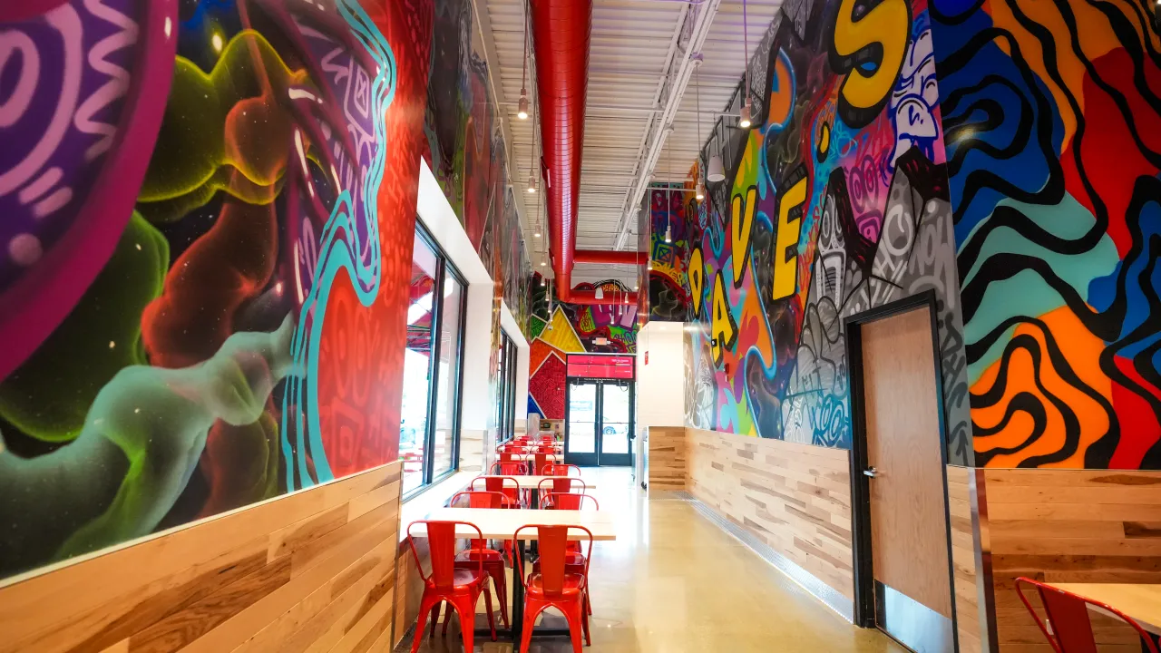 Interior view of vibrant mural at 5530 W. Touhy Ave, Skokie, IL, featuring colorful art and red chairs.